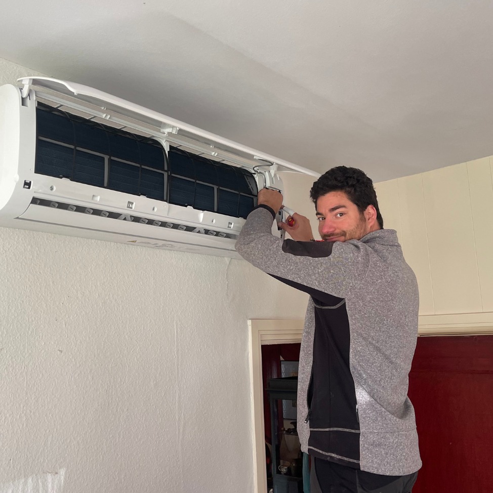 Installateur werkt aan een geopende airco-binnenunit