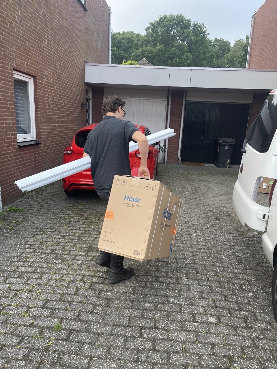 Installateur met materiaal op een oprit