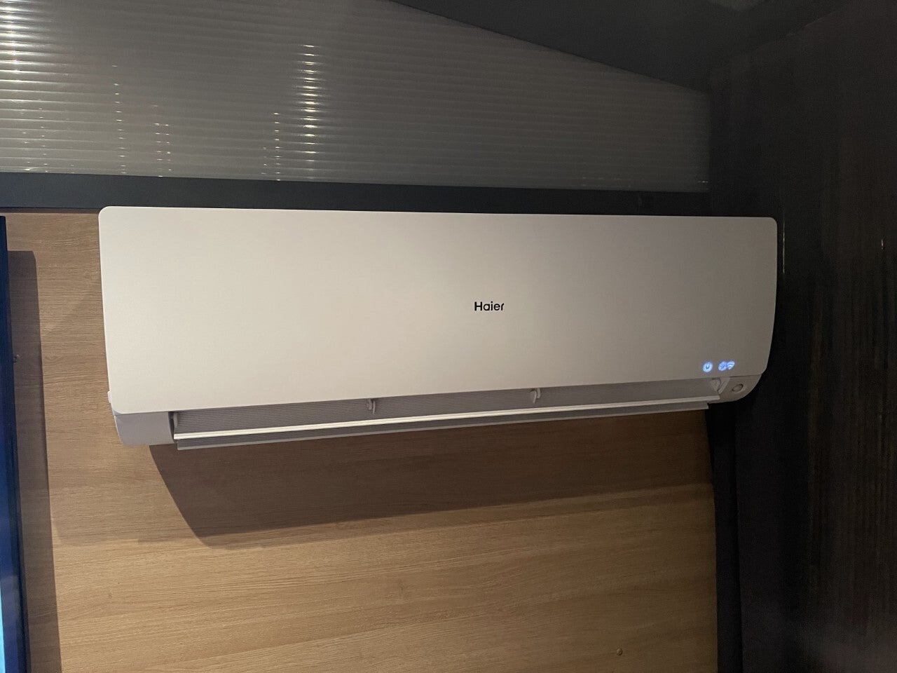 Airco-binnenunit boven een houten wand