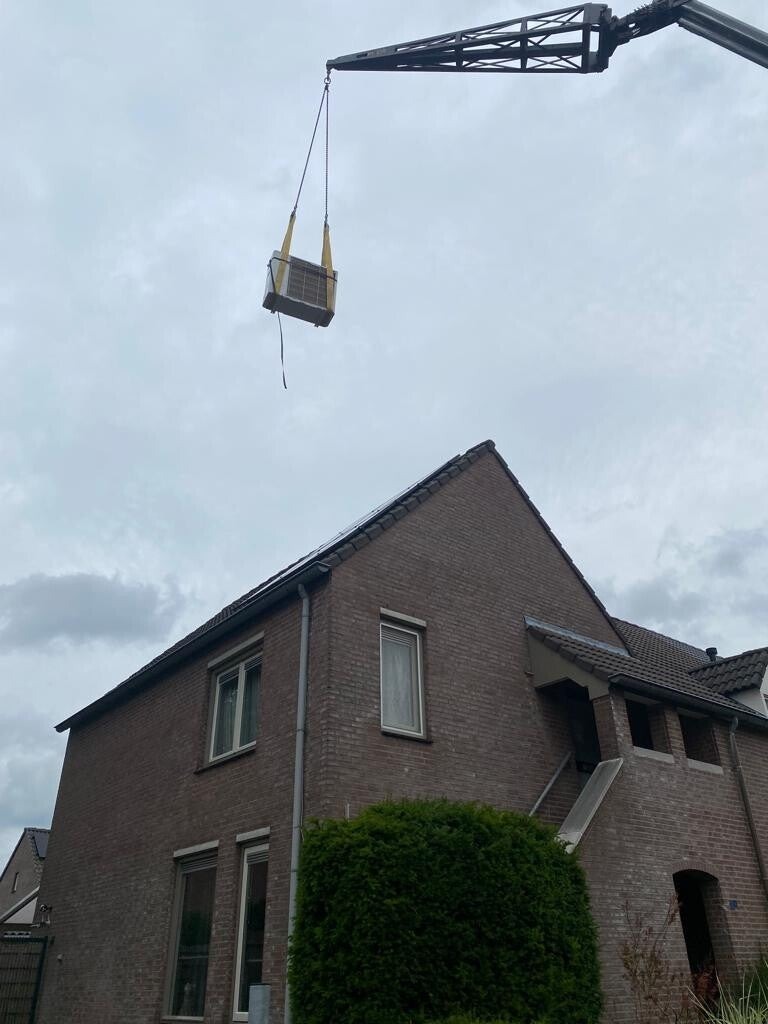 Installatiewerk met een kraan boven een woning door Van den Beucken