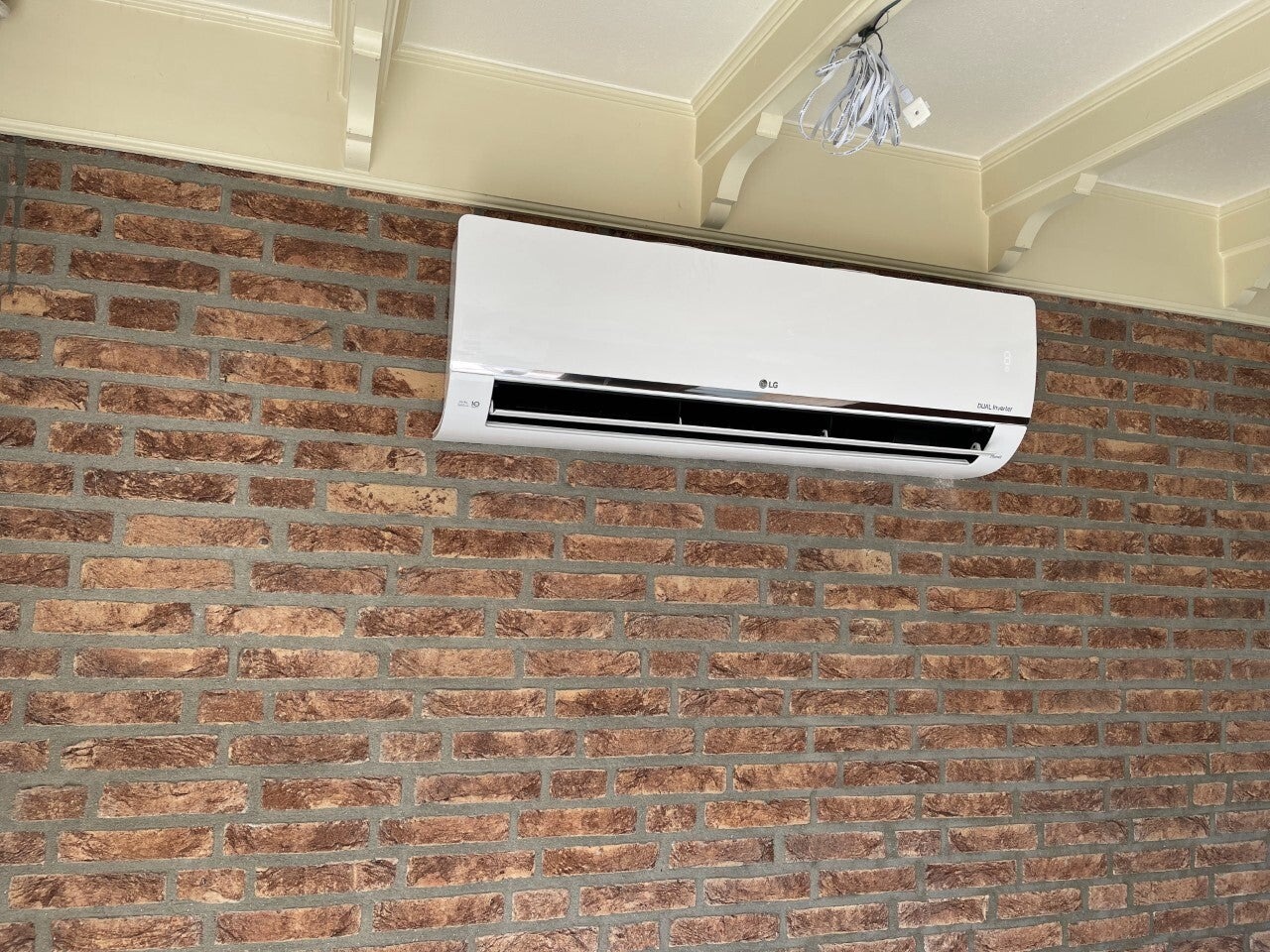 Airco-binnenunit op een bakstenen binnenwand